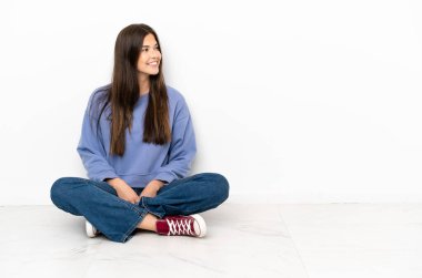 Genç kadın yan bakarak katta oturan