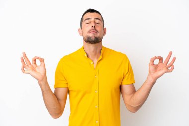 Zen pozisyonunda beyaz arka planda izole edilmiş yakışıklı beyaz bir adam.