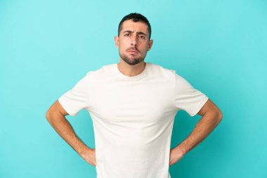 Genç yakışıklı beyaz adam mavi arka planda izole edilmiş kızgın.