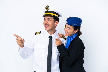 Uçak pilotu ve karışık yarış hostesi beyaz arka planda izole edilmiş bir şekilde gülümseyerek bir fikir sunuyor.