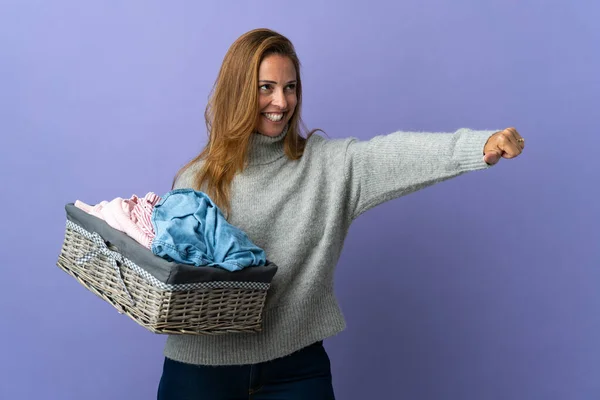 Frau Mittleren Alters Hält Einen Wäschekorb Isoliert Auf Lila Hintergrund — Stockfoto