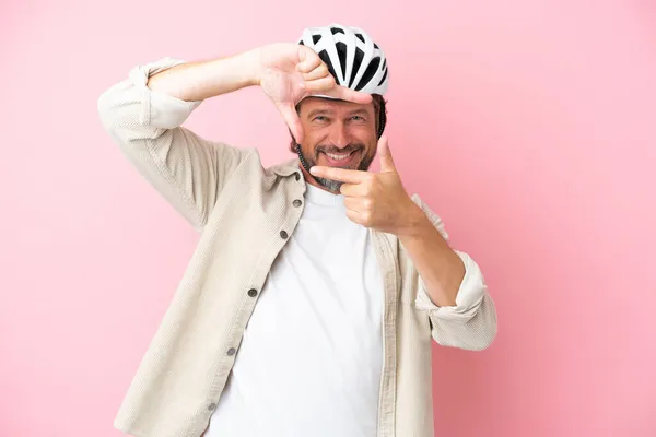 一个戴自行车头盔的高个子男人被隔离在粉色背景的焦点脸上 框框符号 — 图库照片