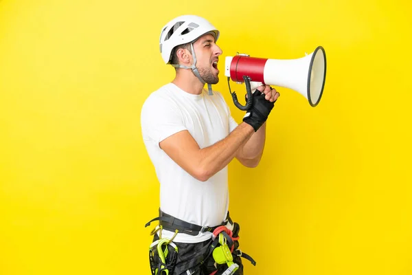 Young Rock Climber Man Isolated Yellow Background Shouting Megaphone — Stock Photo, Image