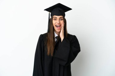 Genç üniversite mezunu beyaz arka planda şaşırmış ve şok olmuş bir yüz ifadesiyle izole edilmiş.