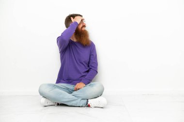 Beyaz arka planda izole bir şekilde yerde oturan Kafkasyalı genç adam bir şey fark etti ve çözüme niyetlendi.