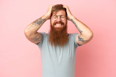 Pembe arka planda izole edilmiş, gergin hareketler yapan genç, beyaz bir adam.