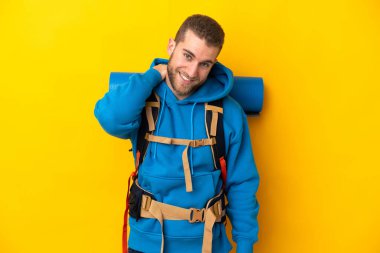 Sarı arka planda izole edilmiş büyük sırt çantalı beyaz bir dağcı.