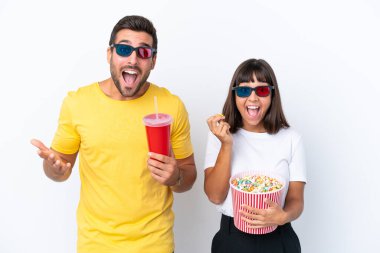 Beyaz arka planda 3 boyutlu gözlüklü ve elinde patlamış mısırla yaşayan genç bir çift.