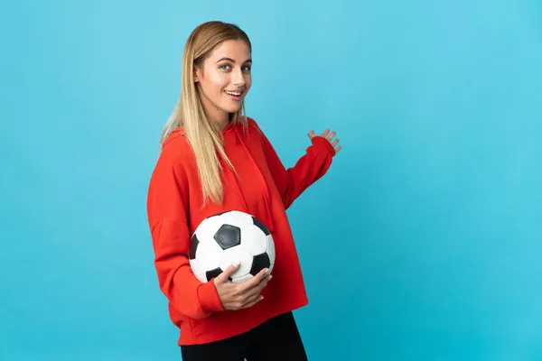 Joven Futbolista Mujer Aislada Sobre Fondo Azul Extendiendo Las Manos —  Fotos de Stock