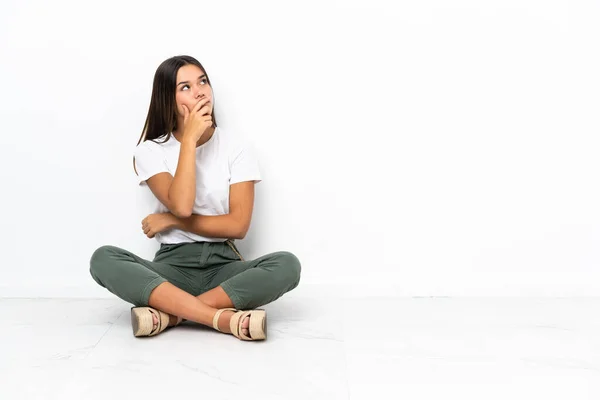 Adolescente Chica Sentada Suelo Teniendo Dudas Con Expresión Cara Confusa — Foto de Stock