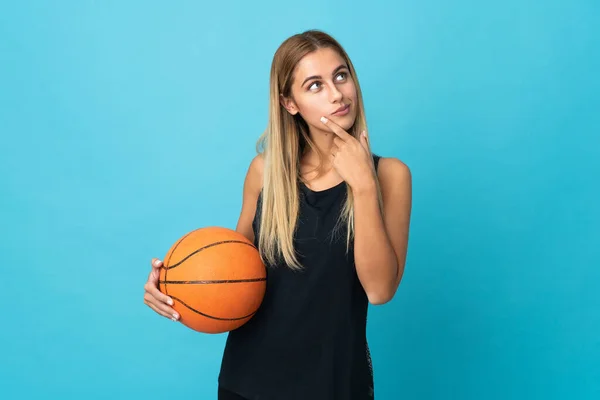 年轻女子在白色背景下打篮球 面带微笑地抬起头看 — 图库照片