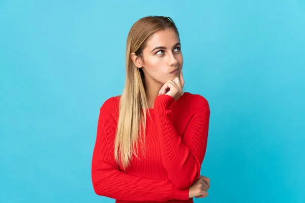 Ung Blond Kvinna Isolerad Blå Bakgrund Tänker Idé Medan Tittar — Stockfoto