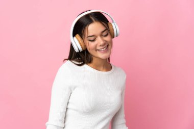 Genç kız mavi arka planda izole edilmiş müzik dinliyor.