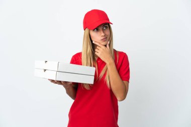 Pizza dağıtan kadın beyaz arka planda izole edilmiş pizza tutuyor. Şüpheleri var.