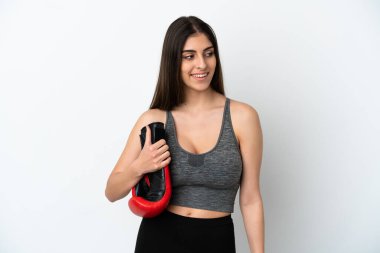 Beyaz arka planda boks eldivenli, beyaz tenli genç bir kadın.