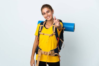 Beyaz arka planda izole edilmiş büyük sırt çantalı genç dağcı kadın iyi bir anlaşma için el sıkışıyor.