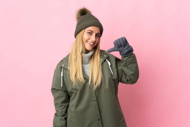 Kış şapkalı genç kadın pembe arka planda soyutlanmış gururlu ve kendini beğenmiş.