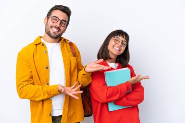 Genç çift beyaz arka planda izole edilmiş. Gelmeleri için ellerini yana uzatıyor.