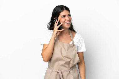 İzole edilmiş beyaz arka planda restoran garsonu cep telefonuyla sohbet ediyor.