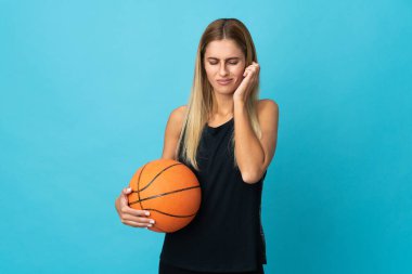 Basketbol oynayan genç bir kadın beyaz arka planda hayal kırıklığına uğramış ve kulaklarını kapatmış.