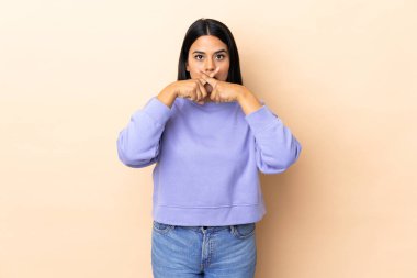 Soyutlanmış bir geçmişi olan genç Latin bir kadın sessizlik işareti gösteriyor.