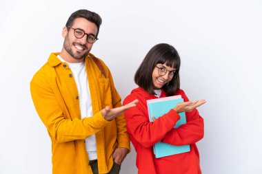 Beyaz arka planda izole edilmiş genç çift geriye dönüp bir ürün sunuyorlar.