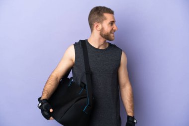 Spor çantalı genç adam beyaz arka planda izole edilmiş.