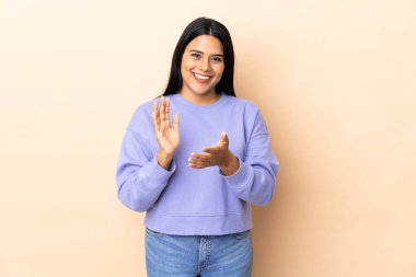 Genç Latin bir kadın münzevi bir arka planda bir konferanstan sonra alkışlıyor.