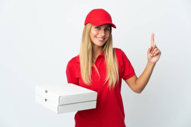 Pizzacı kadın beyaz arka planda izole edilmiş bir pizza tutuyor ve en iyinin işareti olarak parmağını kaldırıyor.