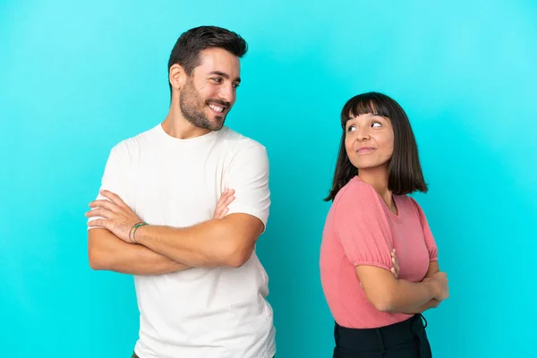 Junges Paar Isoliert Auf Blauem Hintergrund Und Schaut Lächelnd Über — Stockfoto