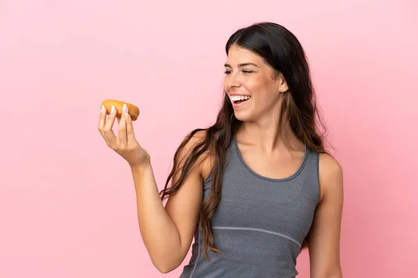 Mulher Caucasiana Jovem Isolado Fundo Rosa Segurando Donuts Com Expressão — Fotografia de Stock