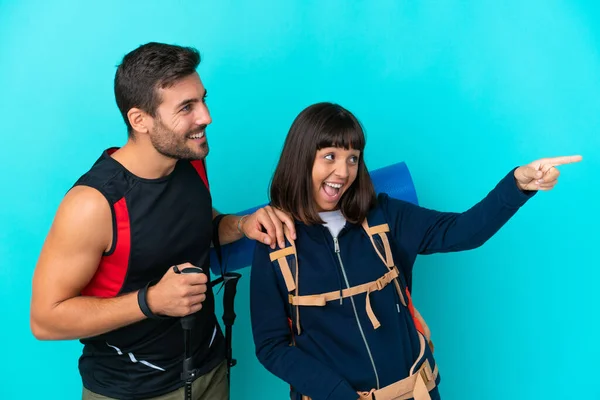 Young Mountaineer Couple Big Backpack Isolated Blue Background Presenting Idea — Stock Photo, Image