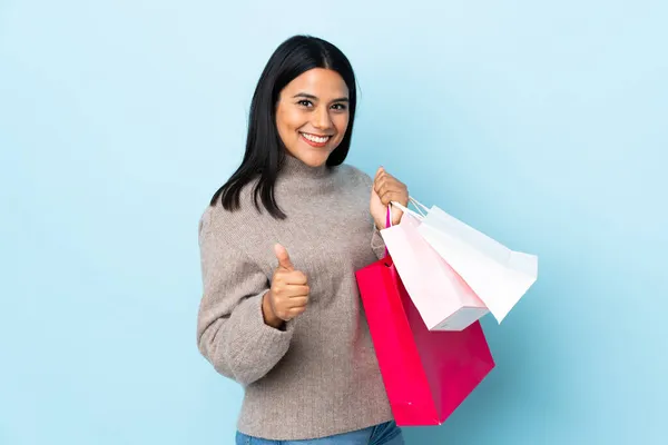 Mavi Arka Planda Izole Edilmiş Genç Latin Kadın Elinde Alışveriş — Stok fotoğraf