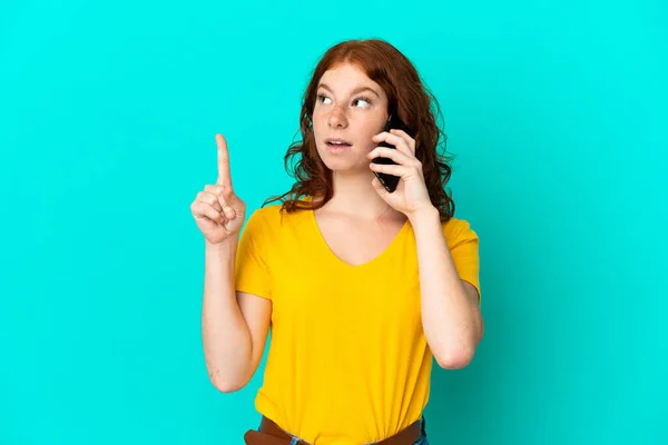 Adolescente Donna Rossastra Utilizzando Telefono Cellulare Isolato Sfondo Blu Pensando — Foto Stock