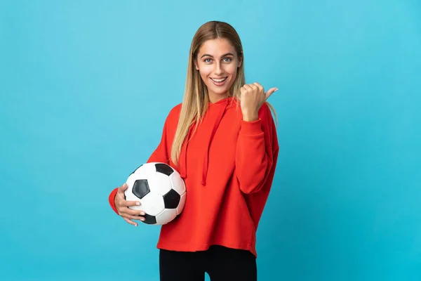 Joven Futbolista Mujer Aislada Sobre Fondo Azul Apuntando Hacia Lado —  Fotos de Stock