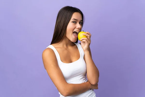 Tiener Meisje Geïsoleerd Paarse Achtergrond Eten Een Appel — Stockfoto