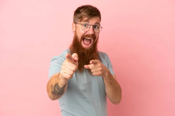 Jonge Roodachtige Blanke Man Geïsoleerd Roze Achtergrond Verrast Wijzen Naar — Stockfoto