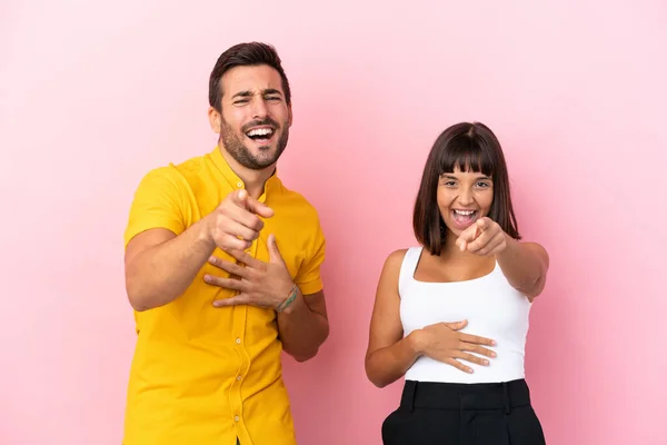 Young Couple Isolated Pink Background Pointing Finger Someone Laughing Lot — Stock Photo, Image