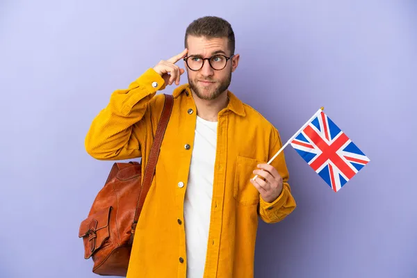 Mladý Běloch Drží Vlajku Spojeného Království Izolovanou Fialovém Pozadí Pochybnostmi — Stock fotografie