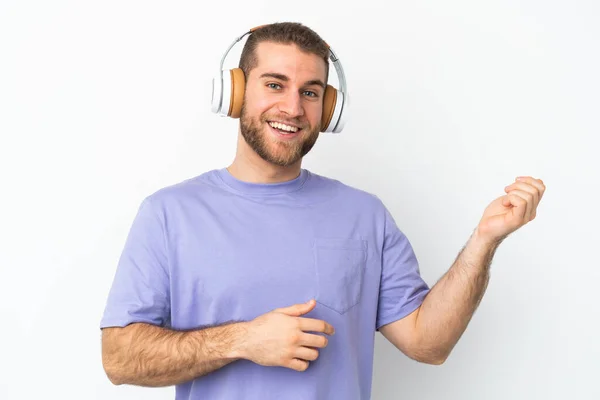 Νεαρός Όμορφος Καυκάσιος Άνδρας Απομονωμένος Λευκό Φόντο Ακούγοντας Μουσική Και — Φωτογραφία Αρχείου