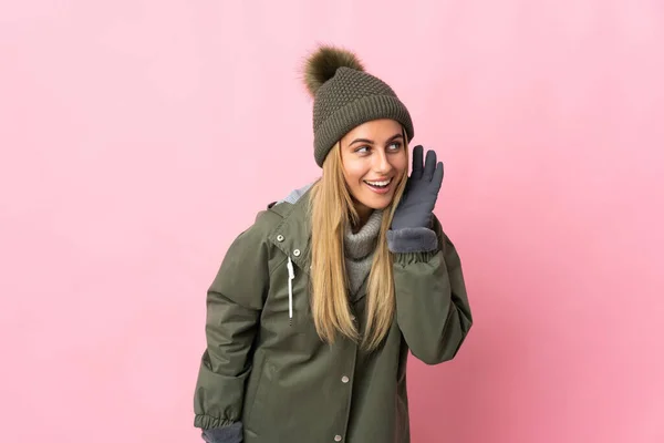 Ung Kvinna Med Vinter Hatt Isolerad Rosa Bakgrund Lyssna Något — Stockfoto