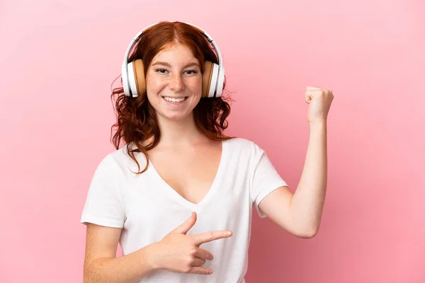 Adolescente Mujer Rojiza Aislada Sobre Fondo Rosa Escuchando Música Haciendo —  Fotos de Stock