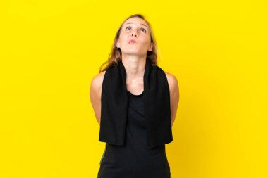 Genç İngiliz kadın beyaz arka planda izole edilmiş ve yukarı bakıyor.