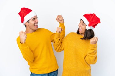 Genç melez çift Noel 'i beyaz arka planda yalnız kutluyor galibiyeti kutluyorlar.