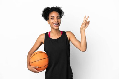 Genç basketbolcu Latin kadın beyaz arka planda izole edilmiş gülümsüyor ve zafer işareti gösteriyor.