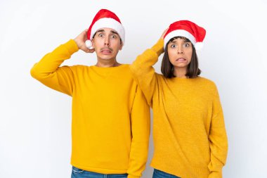 Genç melez çift, Noel 'i beyaz arka planda yalnız kutluyor. Migreni olduğu için el ele tutuşuyorlar.