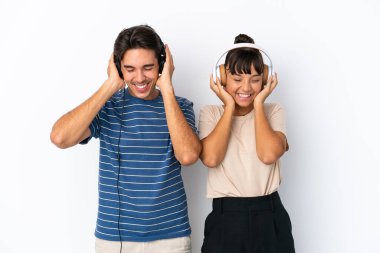 Genç melez arkadaşlar beyaz arka planda izole edilmiş müzik dinliyorlar.