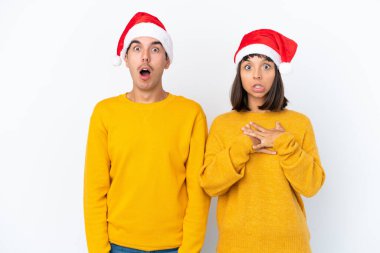 Genç melez çift Noel 'i beyaz arka planda yalnız kutluyor. Şaşırmış ve şok olmuş bir yüz ifadesi var.