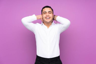 Asyalı yakışıklı adam mavi arka planda yalnız gülüyor.