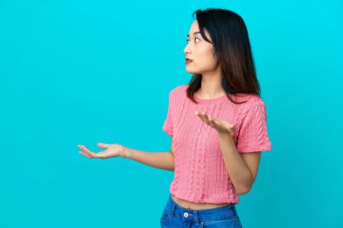 Genç Vietnamlı kadın mavi arka planda izole edildi.